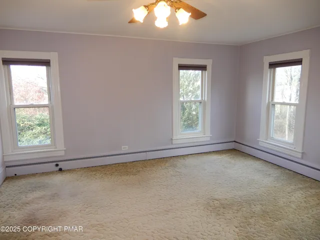 a view of an empty room with a ceiling fan