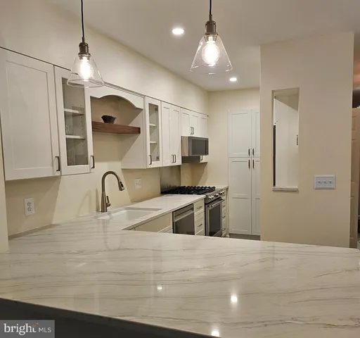 a kitchen with stainless steel appliances granite countertop a sink a stove and a refrigerator