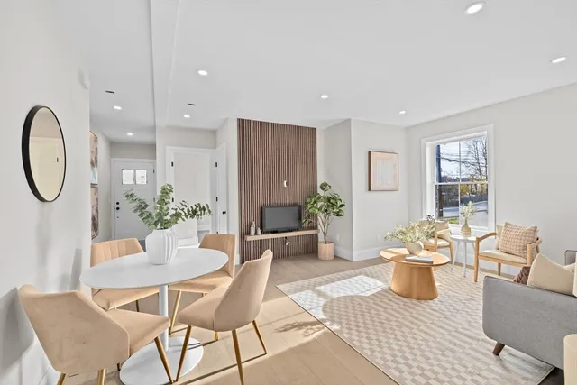 a living room with furniture a potted plant and a chandelier