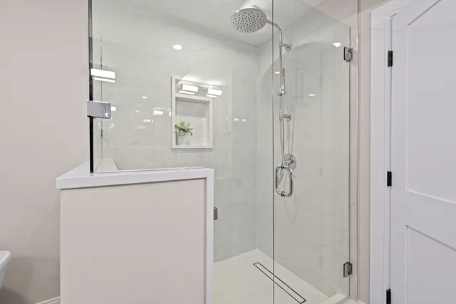 a bathroom with a shower sink and mirror