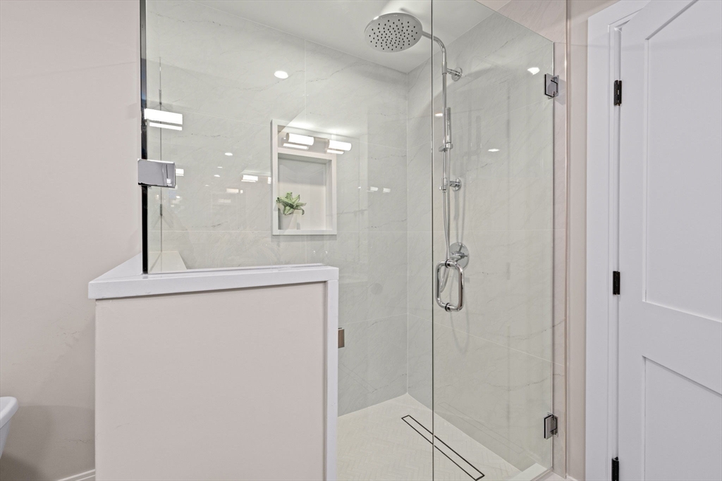 340 Baker Street, Unit 1 Boston, MA 02132 - Photo 29 of 41 a bathroom with a shower sink and mirror