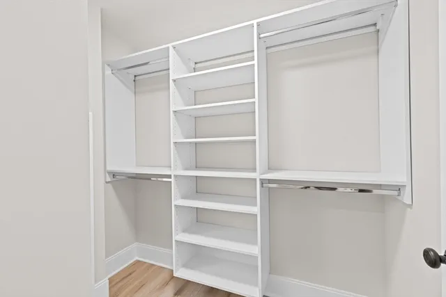 a view of walk in closet with empty racks
