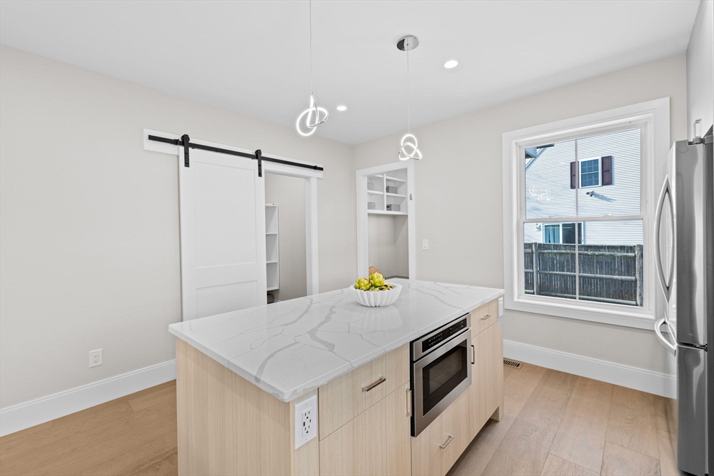 340 Baker Street, Unit 1 Boston, MA 02132 - Photo 9 of 41 a kitchen with a stove a refrigerator and a sink