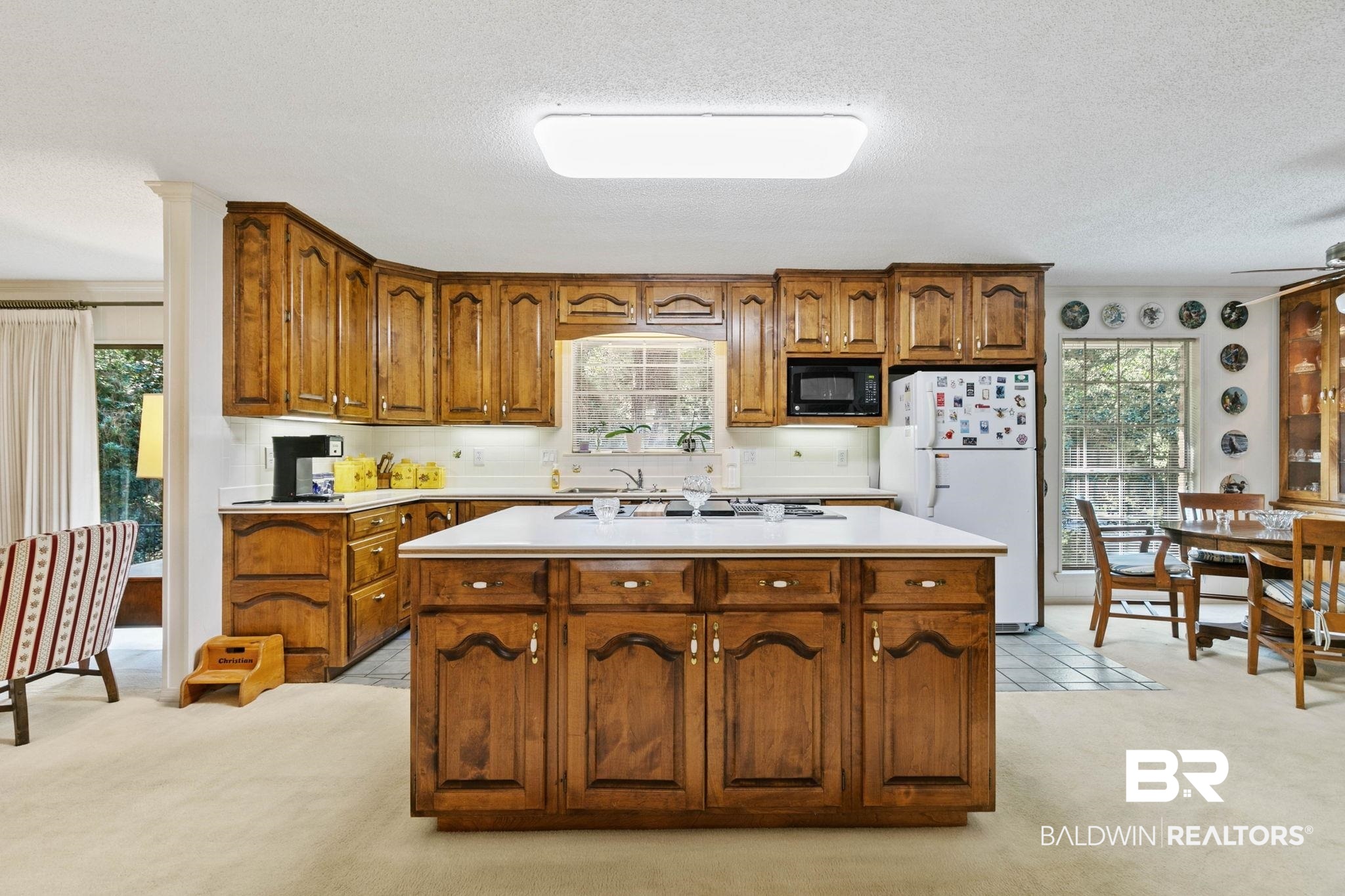 752 Evergreen Street Fairhope, AL 36532 - Photo 13 of 100 Kitchen featuring light countertops, light carpet, freestanding refrigerator, brown cabinets, and a textured ceiling