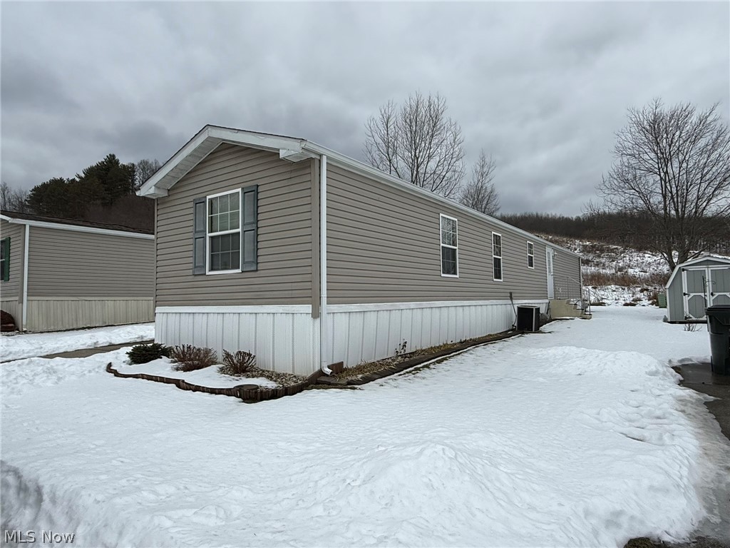 2933 Rabbit Drive Dennison, OH 44621 - Photo 1 of 28 Snow covered property featuring a storage shed and a cooling unit