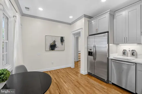 a kitchen with stainless steel appliances granite countertop a refrigerator and a stove top oven