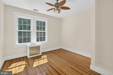 a view of a livingroom with wooden floor and a ceiling fan