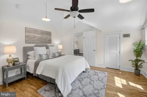a spacious bedroom with bed and a potted plant
