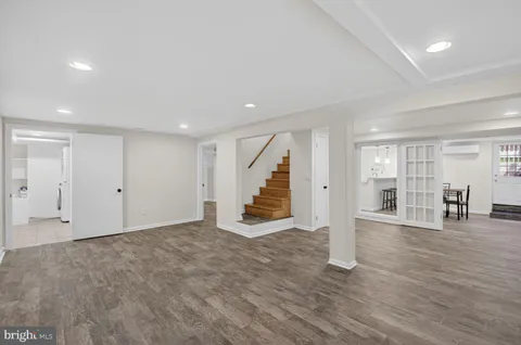 a view of an empty room with wooden floor and stairs