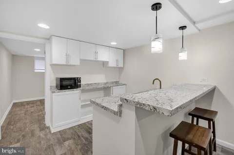 a kitchen with a sink a stove a refrigerator and white cabinets