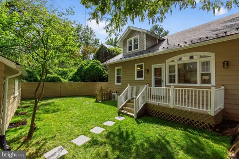 a view of a chair and table in backyard of the house