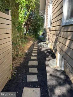 a view of a pathway of a house with wooden fence