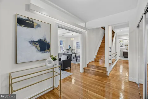 a view of staircase with white walls and frames on wall and wooden floor