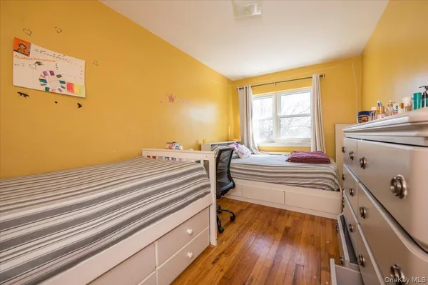 a spacious bedroom with a bed and wooden floor