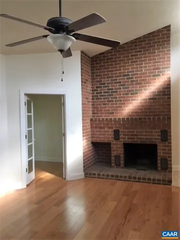 a view of empty room with fireplace and wooden floor