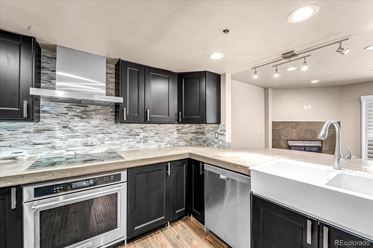 350 Detroit Street, Unit 103 Denver, CO 80206 - Photo 6 of 15 a kitchen with stainless steel appliances granite countertop a sink and stove