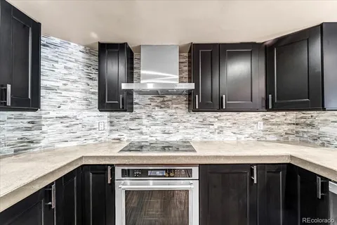a kitchen with granite countertop stainless steel appliances wooden cabinets and a sink