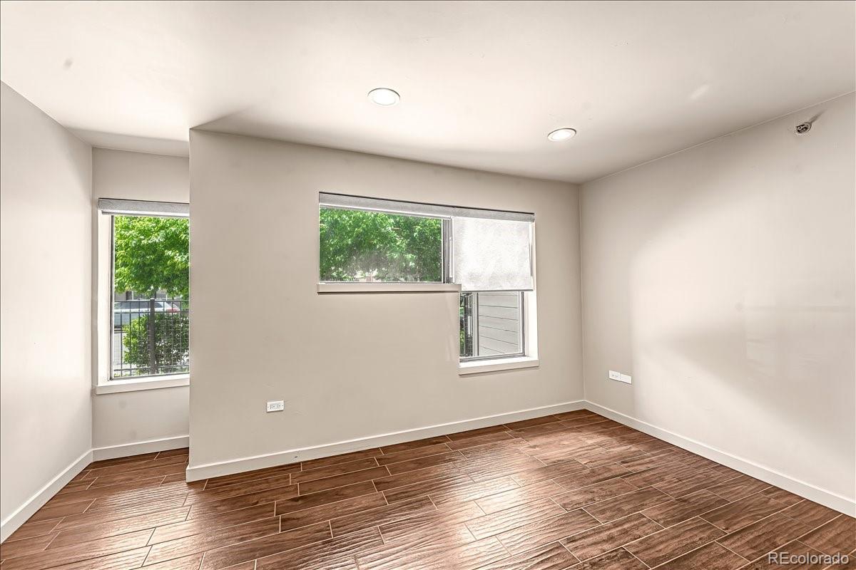 350 Detroit Street, Unit 103 Denver, CO 80206 - Photo 8 of 15 an empty room with wooden floor and windows