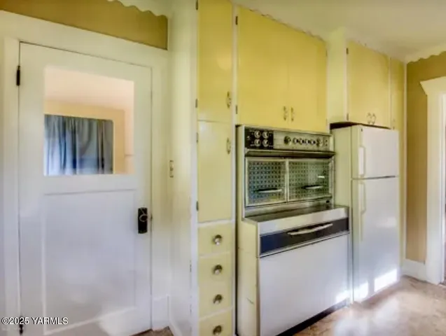 a kitchen with a refrigerator and a stove