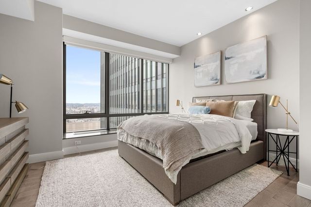 a large bed sitting in a room next to a window