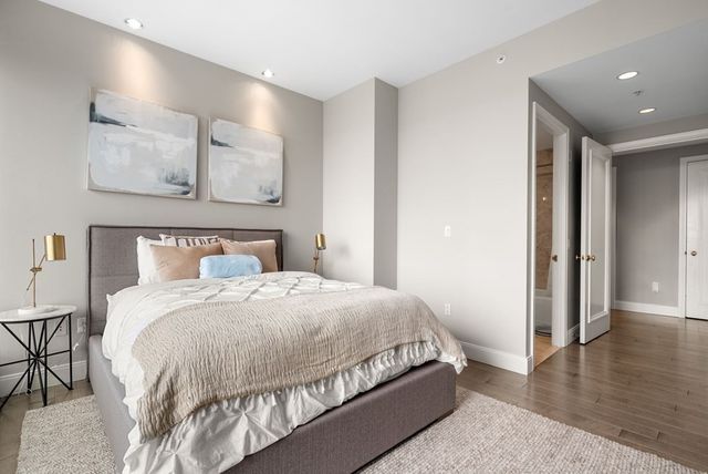 a bedroom with a large bed and wooden floor