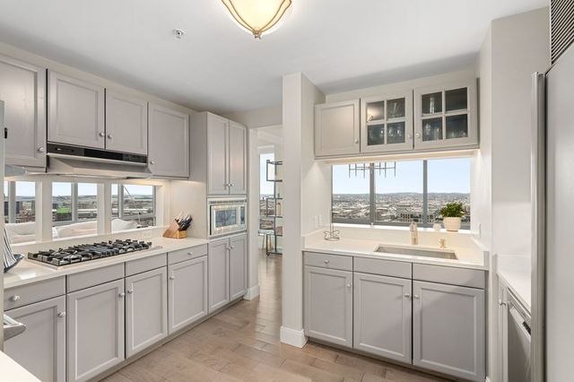 a kitchen with white cabinets and sink