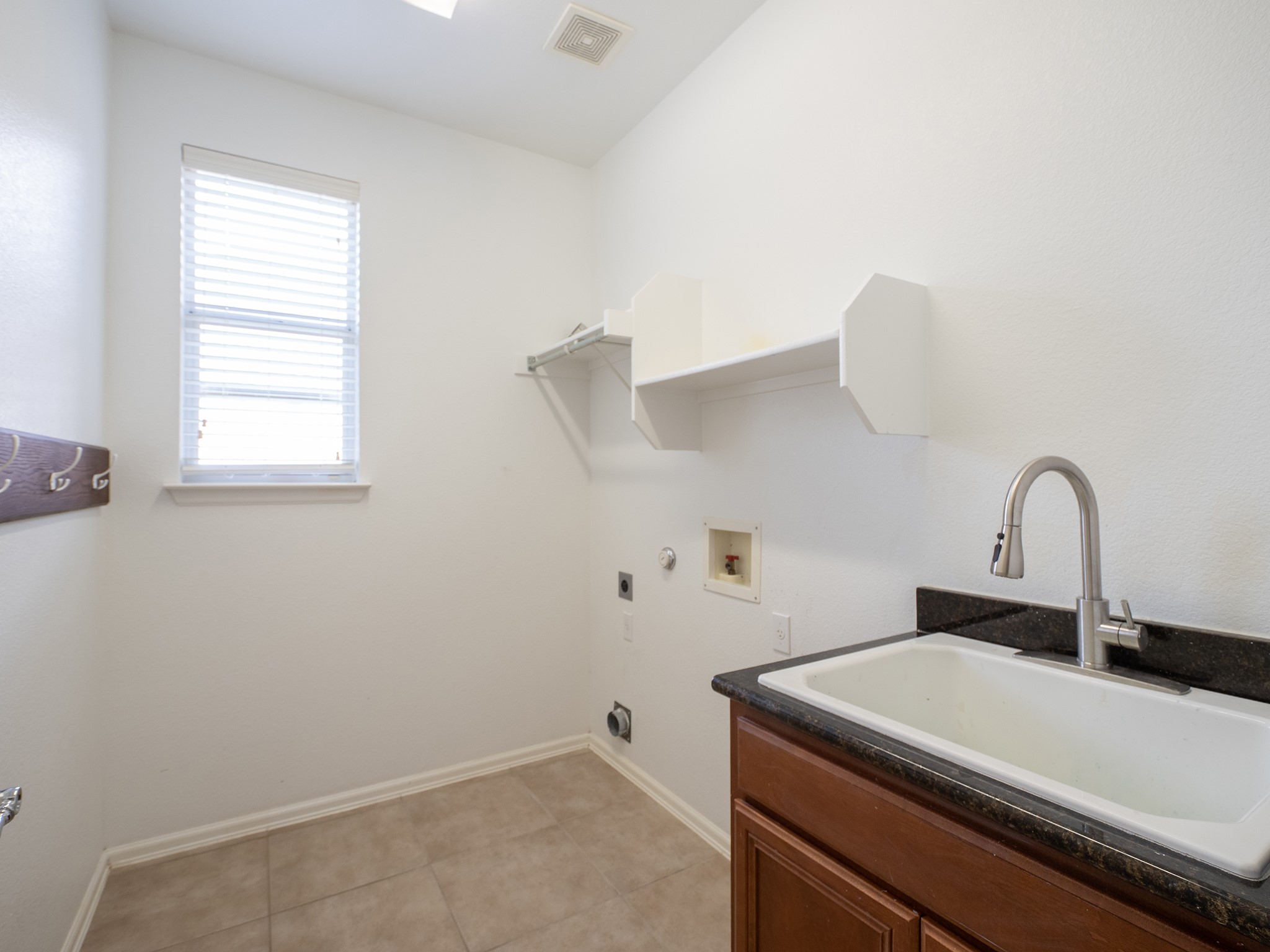 572 Big Meadow Road Austin, TX 78737 - Photo 24 of 32 Functional laundry space featuring a practical utility sink and convenient shelving.