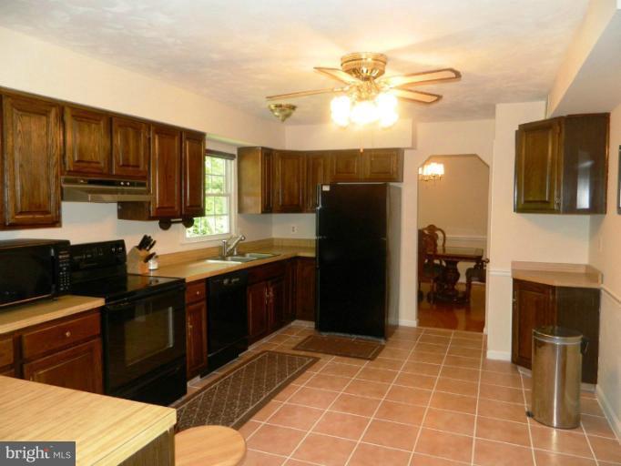 13289 Kenny Road Woodbridge, VA 22193 - Photo 11 of 23 a kitchen with a sink refrigerator and cabinets