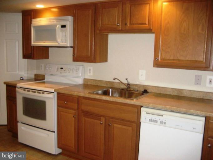 13289 Kenny Road Woodbridge, VA 22193 - Photo 4 of 23 a kitchen with a sink stove and cabinets