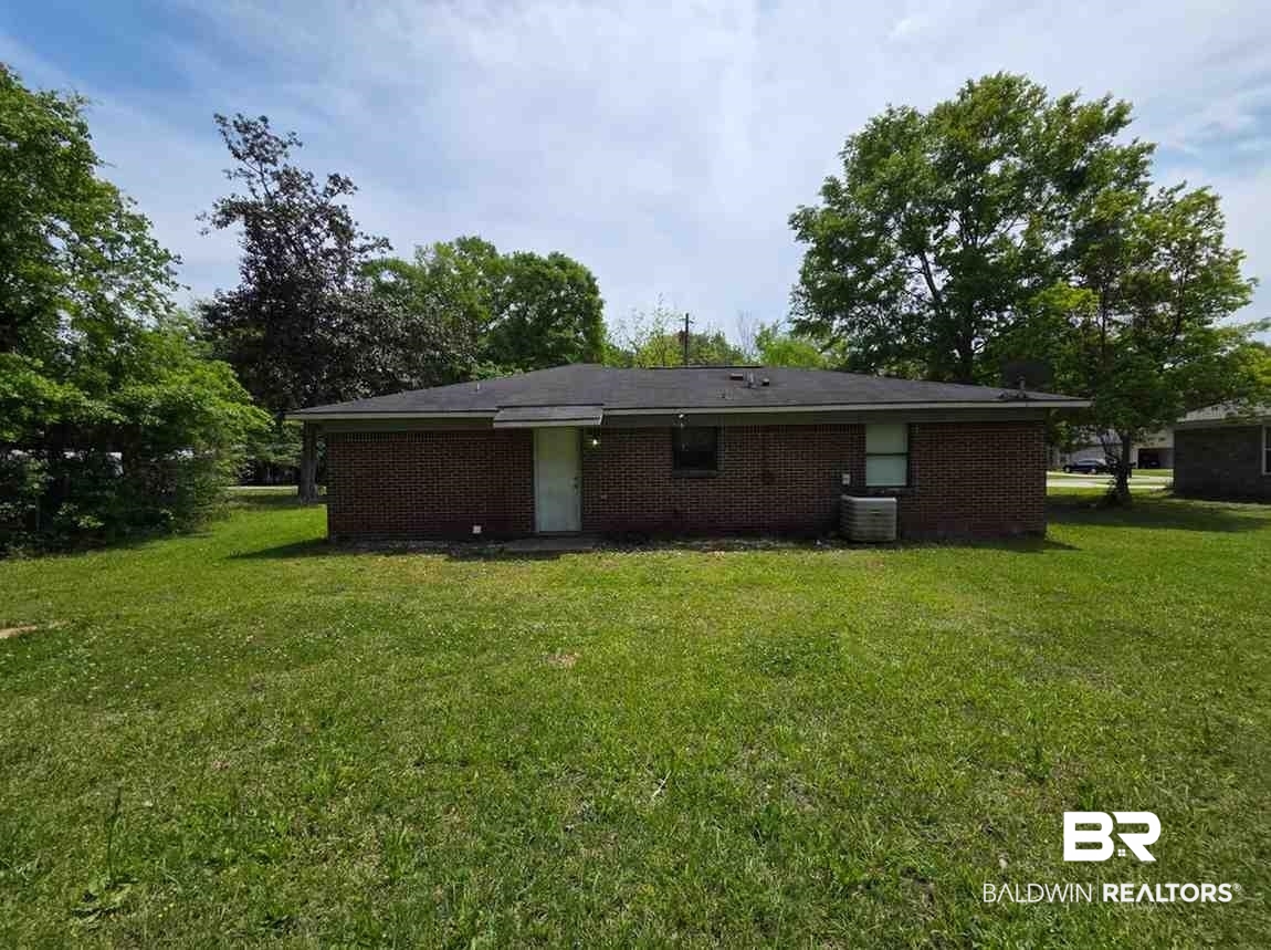 106 West 16th Street Bay Minette, AL 36507 - Photo 5 of 19 Rear view of house featuring a yard, brick siding, and central AC