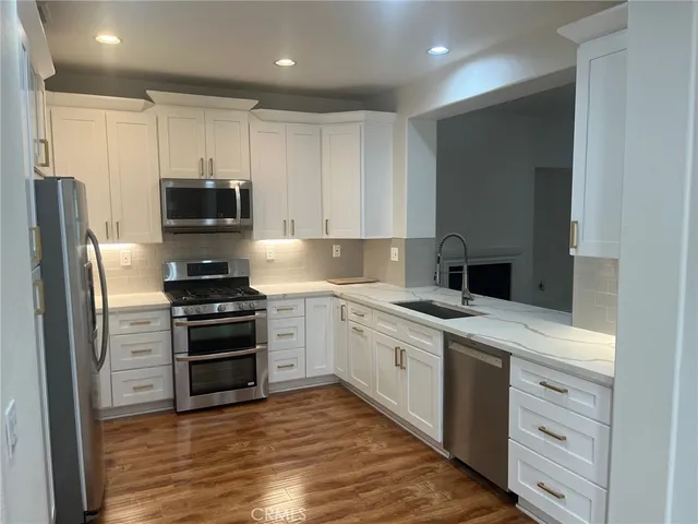 a kitchen with stainless steel appliances a stove a sink and a refrigerator