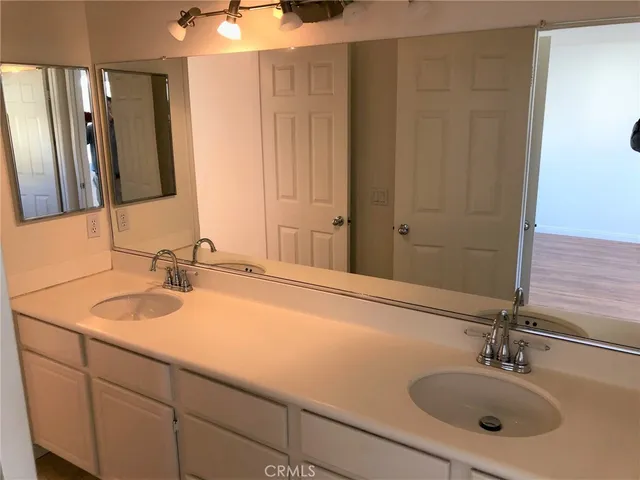 a bathroom with a double vanity sink and a mirror
