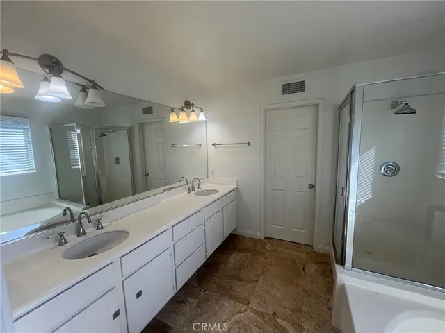 a spacious bathroom with a granite countertop tub sink and mirror