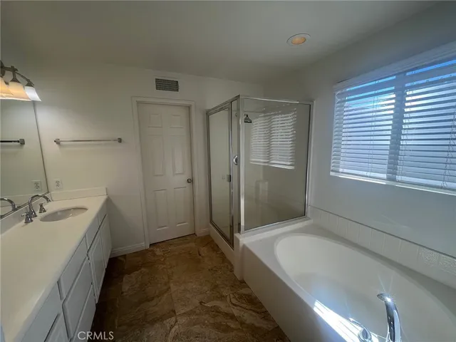 a bathroom with a tub a sink a window and a shower