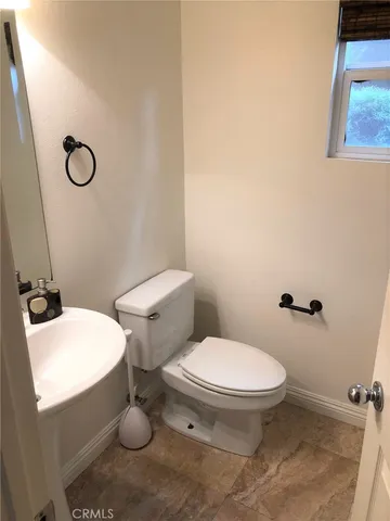 a white toilet sitting next to a bathroom sink and a tub