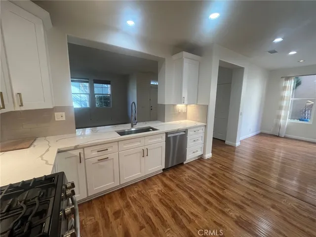 a large kitchen with stainless steel appliances a large counter top a stove and a refrigerator