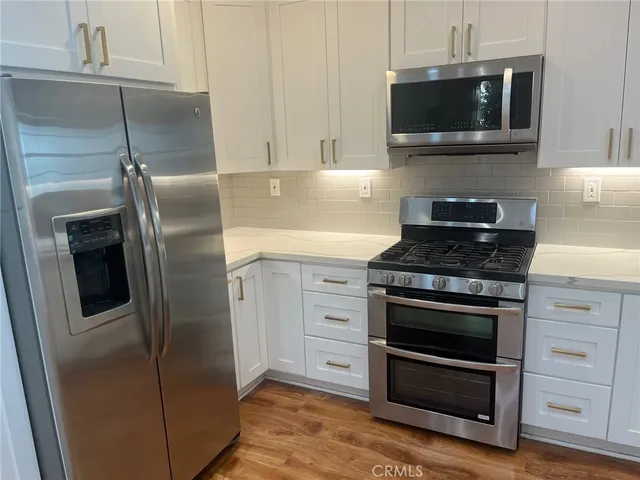 a kitchen with stainless steel appliances wooden cabinets and stove