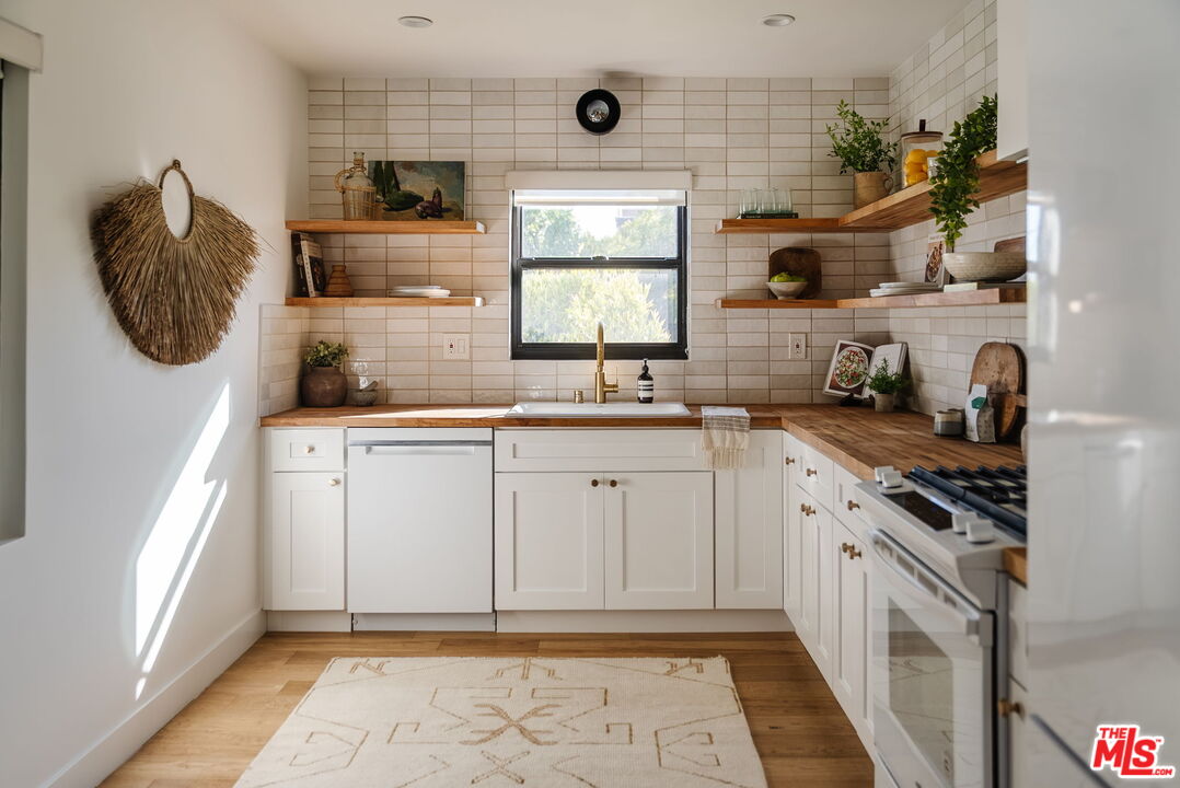 1943 12th, Unit 2 Santa Monica, CA 90404 - Photo 19 of 38 a kitchen with stainless steel appliances granite countertop a sink and a stove