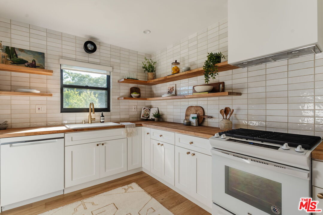 1943 12th, Unit 2 Santa Monica, CA 90404 - Photo 2 of 38 a kitchen with stainless steel appliances granite countertop a sink and cabinets