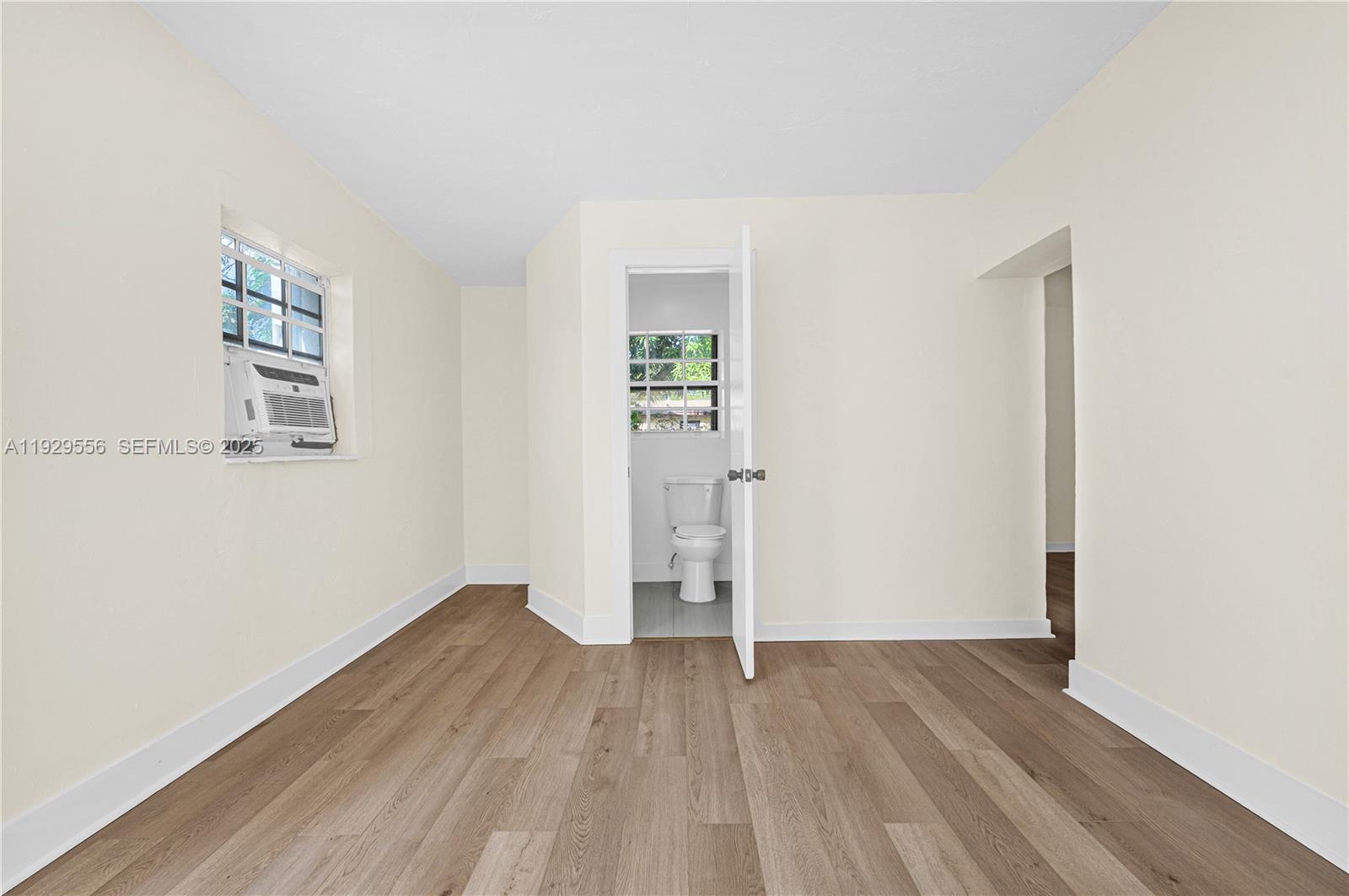 47 Northwest 49th Street, Unit 3 Miami, FL 33127 - Photo 5 of 47 an empty room with wooden floor and windows