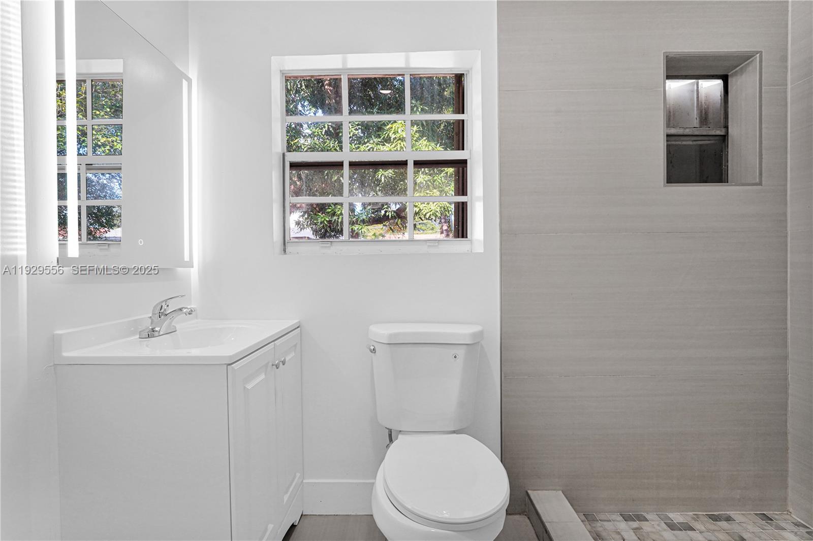 47 Northwest 49th Street, Unit 3 Miami, FL 33127 - Photo 6 of 47 a white toilet sitting next to a bathroom sink