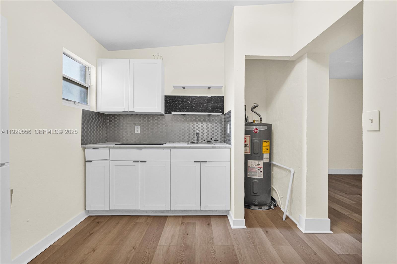 47 Northwest 49th Street, Unit 3 Miami, FL 33127 - Photo 10 of 47 a kitchen with cabinets and wooden floor