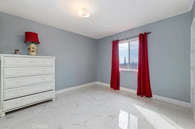 a room with a white bed and a dresser