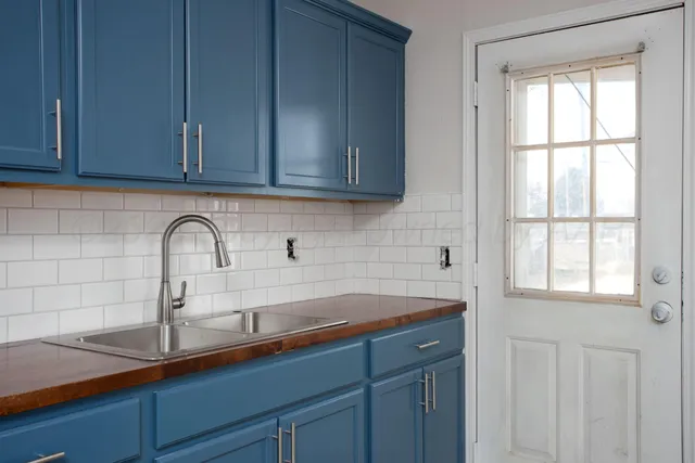 a kitchen with granite countertop white cabinets and a sink