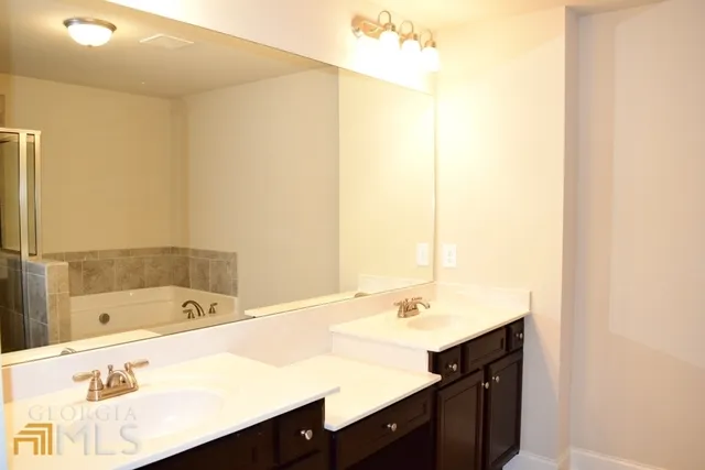 a bathroom with a tub sink and mirror