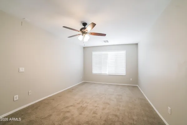 an empty room with a window and a fan