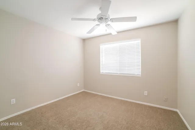 an empty room with a window and a fan