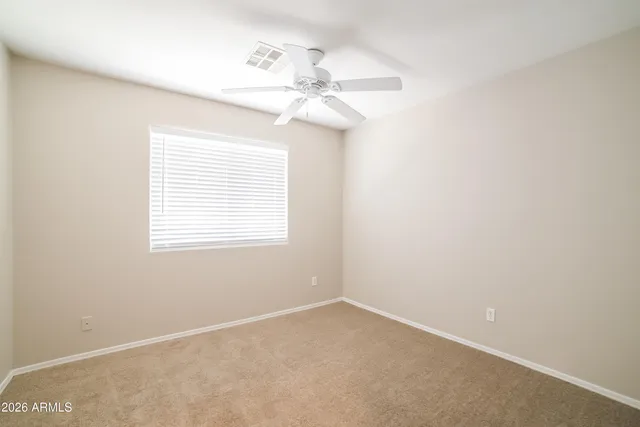 an empty room with a window and a fan