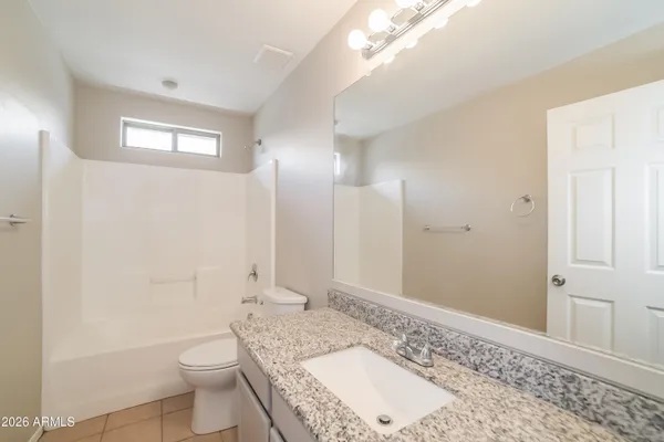 a bathroom with a granite countertop sink a toilet and shower