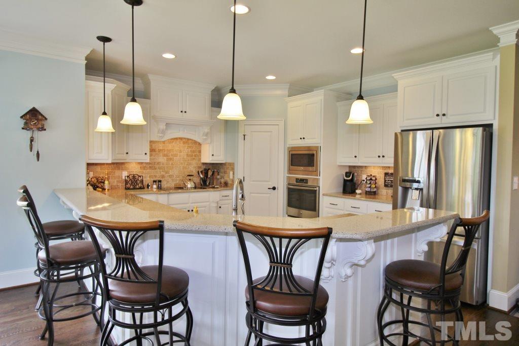 5820 Farmstead Road Bailey, NC 27807 - Photo 16 of 25 a kitchen with stainless steel appliances a dining table chairs and a refrigerator